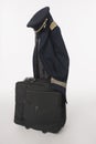 Flight crew uniform and hat hanging on trolley baggage on white background Royalty Free Stock Photo