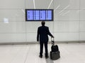 Flight Departures information board Bahrain Airport, man looks at schedule on electronic scoreboard, concept passenger traffic, Royalty Free Stock Photo