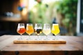 flight of different saison beers on wooden table