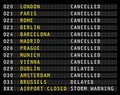 Flight information display on an airport showing cancelled flights, storm warning,