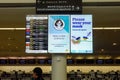 Flight information display service board in airport providing flight arrivals and departure times with covid messaging and Royalty Free Stock Photo