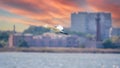 The flight of the little egret in beautiful sunset sky over water. A heron flies over a city pond during an orange-pink sunset Royalty Free Stock Photo