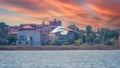 The flight of the little egret in beautiful sunset sky over water. A heron flies over a city pond during an orange-pink sunset Royalty Free Stock Photo