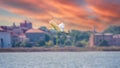 The flight of the little egret in beautiful sunset sky over water. A heron flies over a city pond during an orange-pink sunset Royalty Free Stock Photo