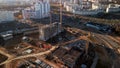 Flight over city blocks. Multi-storey buildings and construction site. Flying in the backlight of the setting sun. Aerial Royalty Free Stock Photo