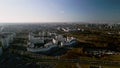 Flight over city blocks. Multi-storey buildings and construction site. Flying in the backlight of the setting sun. Aerial Royalty Free Stock Photo