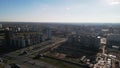 Flight over city blocks. Multi-storey buildings and construction site. Flying in the backlight of the setting sun. Aerial Royalty Free Stock Photo