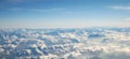 Flight over the clouds and snowy Alps on a sunny day Royalty Free Stock Photo