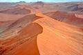 Flight over huge orange dunes in Namib Desert, Namibia. Aerial view of ridge of dunes. Royalty Free Stock Photo