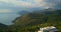 Flight over mountains of Aegina island, Greece on sunny day with dramatic sky.