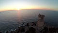 Flight over old tower with background of the sea at sunset. Tour de la Parata, Ajaccio, Corsica, France. Aerial view.