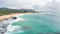 Flight over rocky coast of tropical island of Oahu Hawaii. View of Sandy Beach. Pacific Ocean Coastline. White clouds Royalty Free Stock Photo