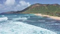 Flight over rocky coast of tropical island of Oahu Hawaii. View of Sandy Beach. Pacific Ocean Coastline. White clouds Royalty Free Stock Photo