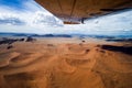 Sossusvlei orange dunes seen from plane, aerial view. Flight over orange desert of Namibia, Africa