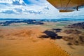 Namibia, flight over Sossusvlei. Border of orange dunes and rocks seen from plane, aerial view Royalty Free Stock Photo