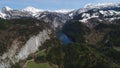 Flight over Toplitz lake in austrian Alps. Easiley snow-caped mountains and beautiful blue lake among them. Kammersee