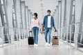 Flight Resumption. Black Couple Wearing Protective Masks Walking With Suitcases At Airport Royalty Free Stock Photo