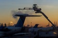 Flight safety with airport staff preparing airplane for the flight deicing the wing of the aircraft at winter from