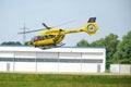 In flight shot of a departing yellow ADAC rescue helicopter. German search and rescue system.