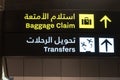 Flight transfer sign and baggage claim sign in airport in English and Arabic Royalty Free Stock Photo