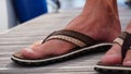 Flip flop with man foot. Summer shoes with bare feet. Flip flops for warm days and holiday walks in the outdoors. Royalty Free Stock Photo