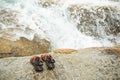 Flip flop on stone with splash wave white water at coast of sea ocean. Royalty Free Stock Photo