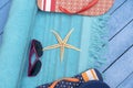 Flip-flops, beach towel and sunglasses on wooden table. Royalty Free Stock Photo