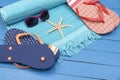 Flip-flops,beach towel and sunglasses on wooden table. Royalty Free Stock Photo