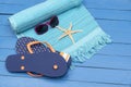 Flip-flops,beach towel and sunglasses on wooden table. Royalty Free Stock Photo