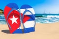 Flip flops with Cuban flag on the beach. Cuba resorts, vacation, tours, travel packages concept. 3D rendering