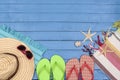 Flip-flops, hat, beach towel and sunglasses on wooden table. Royalty Free Stock Photo