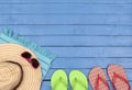 Flip-flops, hat, beach towel and sunglasses on wooden table. Royalty Free Stock Photo