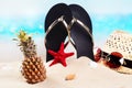 Beach flip flops, hat and sunglasses on the beautiful sandy beach near the ocean. Copy space Royalty Free Stock Photo