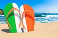 Flip flops with Irish flag on the beach. Ireland resorts, vacation, tours, travel packages concept. 3D rendering