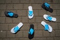 Flip flops lie on the pavement in a semicircle.