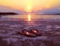 Flip flops with lovely hearts on the beach at sunset