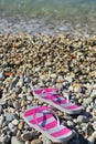 Flip flops on pebbled beach closeup Royalty Free Stock Photo