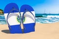 Flip flops with Salvadoran flag on the beach. El Salvador resorts, vacation, tours, travel packages concept. 3D rendering