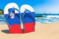 Flip flops with Slovenian flag on the beach. Slovenia resorts, vacation, tours, travel packages concept. 3D rendering Royalty Free Stock Photo