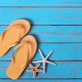 Flip flops starfish old distressed bright blue beach wood background square Royalty Free Stock Photo