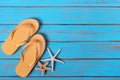 Flip flops starfish old distressed bright blue beach wood background tropical Royalty Free Stock Photo