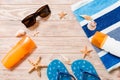 Flip flops, straw hat, starfish, sunscreen bottle, body lotion spray on wooden background top view . flat lay summer beach sea Royalty Free Stock Photo