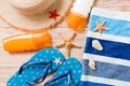 Flip flops, straw hat, starfish, sunscreen bottle, body lotion spray on wooden background top view . flat lay summer beach sea