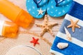 Flip flops, straw hat, starfish, sunscreen bottle, body lotion spray on wooden background top view . flat lay summer beach sea