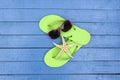 Flip-flops and sunglasses on wooden table. Royalty Free Stock Photo