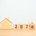 flip 2023 to 2024 block with house model. real estate, Home loan, tax, investment, financial, savings and New Year Resolution Royalty Free Stock Photo