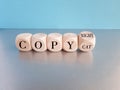 Flipped a cube and changes the word 'copycat' to 'copyright'. Beautiful blue background. Business concept Royalty Free Stock Photo