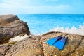 Flippers or fins on a rock beach wave sea and blue sky Royalty Free Stock Photo