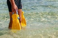 Flippers in the hands of a man on the Mediterranean coast Royalty Free Stock Photo