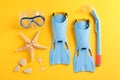 Flippers, snorkel, diving mask and starfishes on yellow background Royalty Free Stock Photo